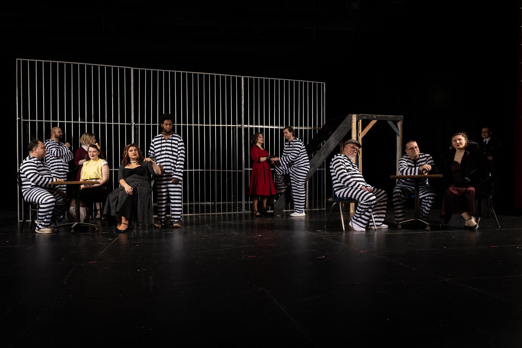 prison inmates in striped suits with their visiting wives in 50s dresses