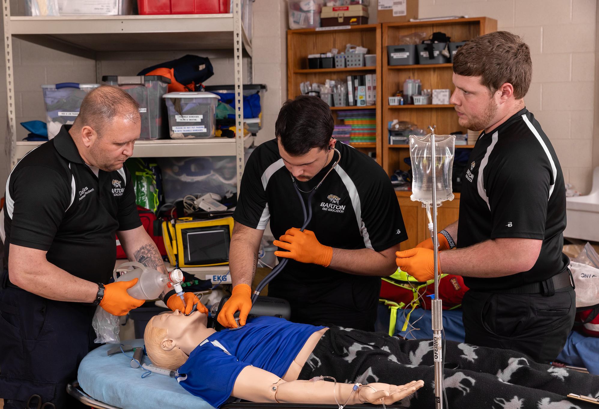 paramedic students work on a dummy for a drill