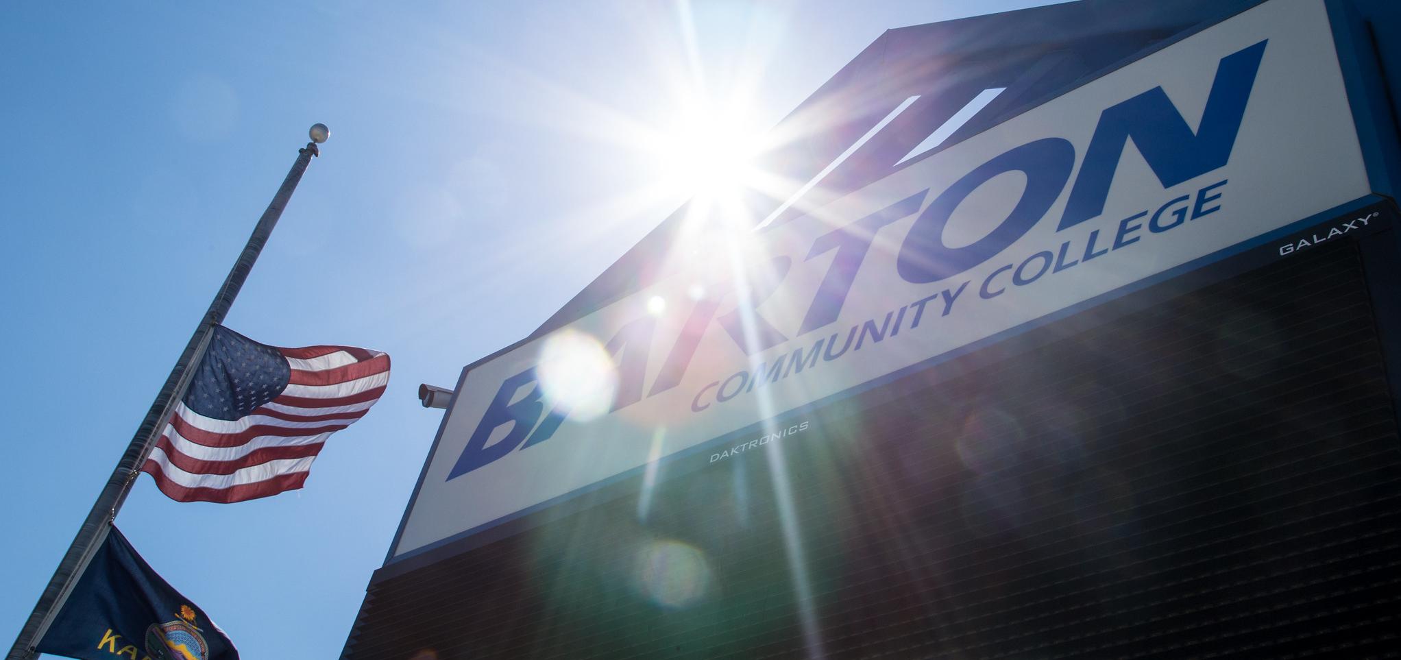 An American flag waves by the Barton welcome sign