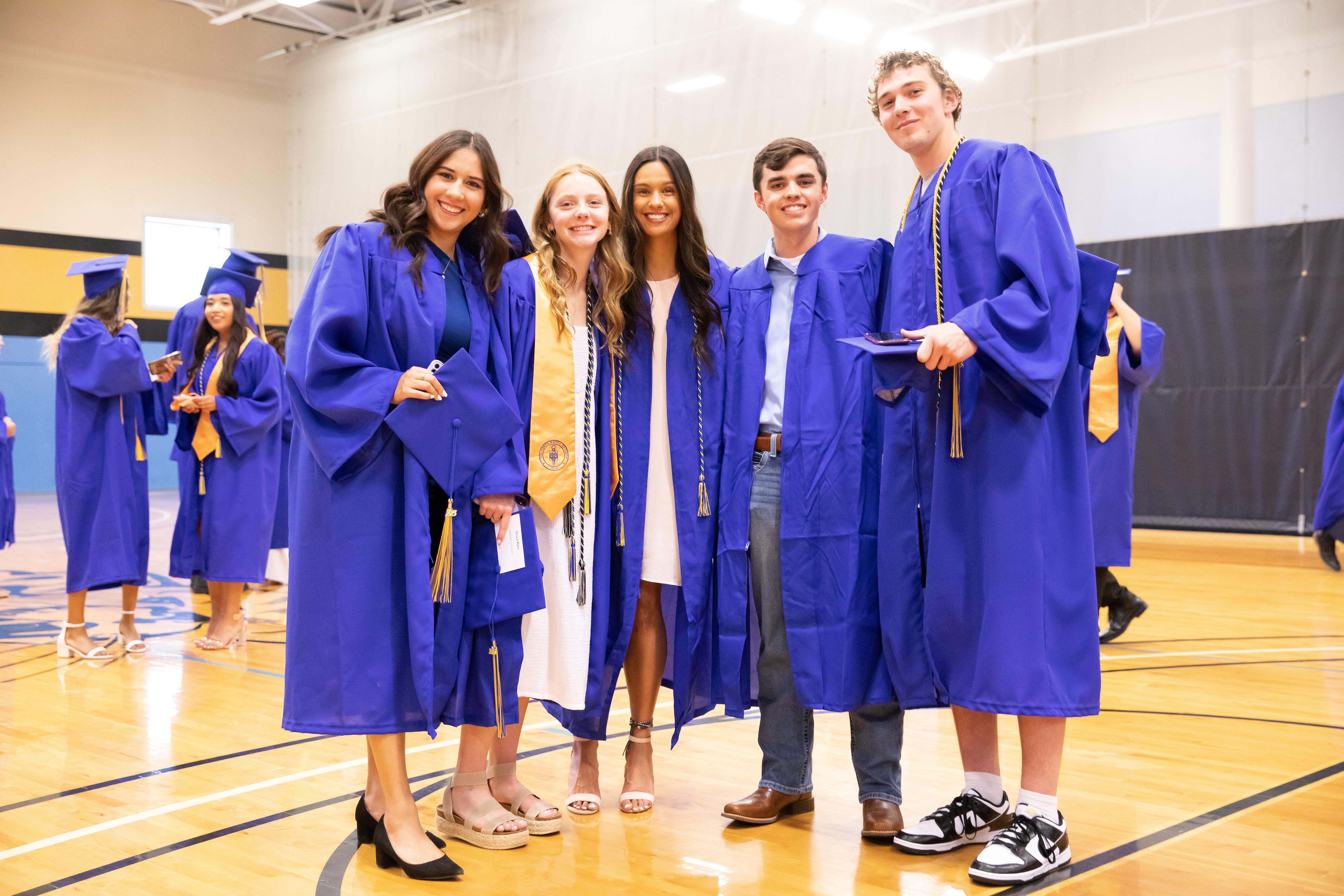 Students pause for a photo before the 2023 commencement ceremony in the Barton Gym.