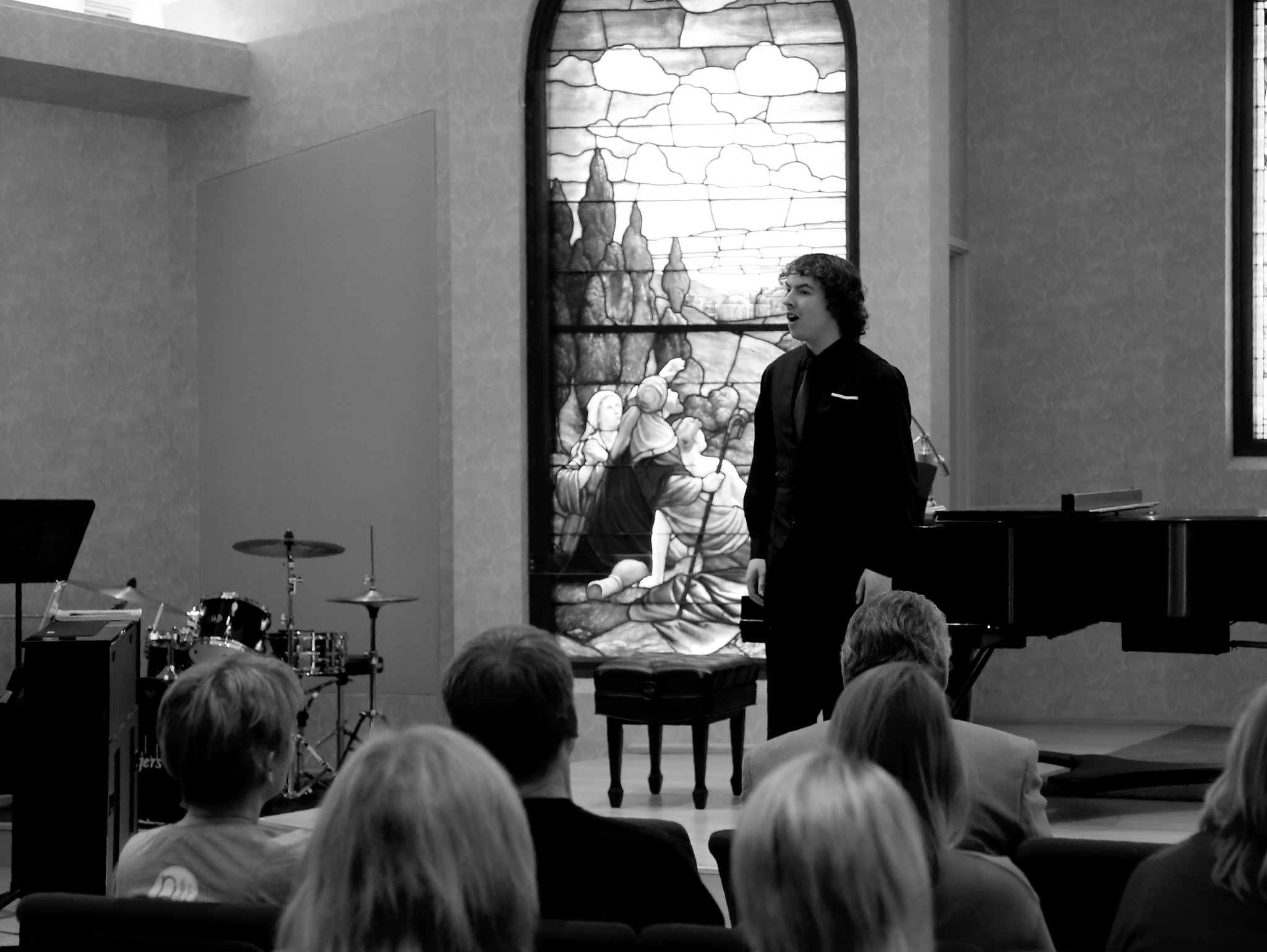 A male student sings at a recital.