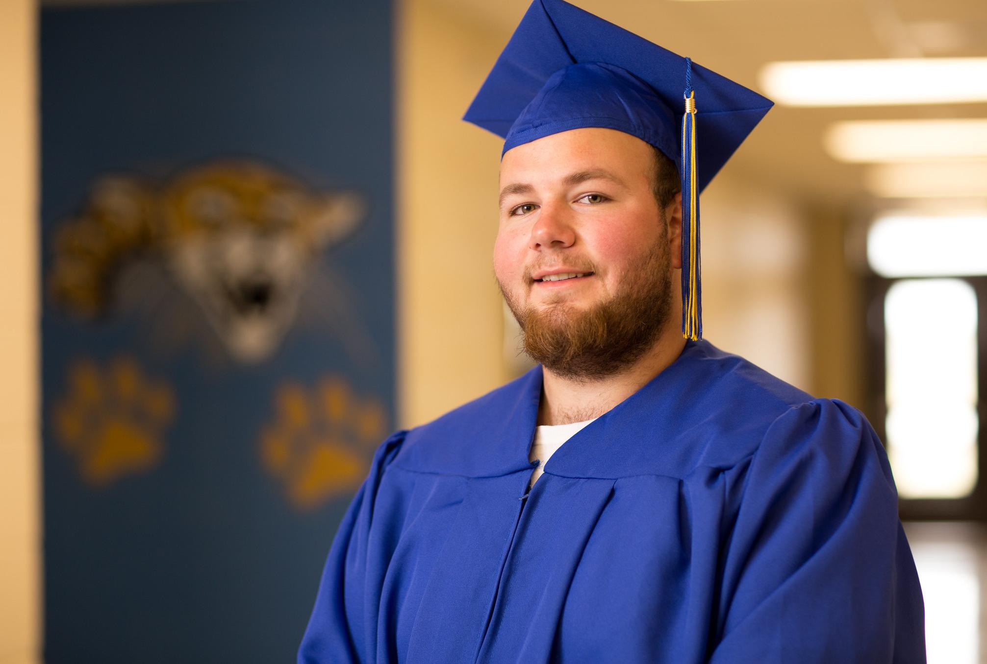 student in cap and gown in prison