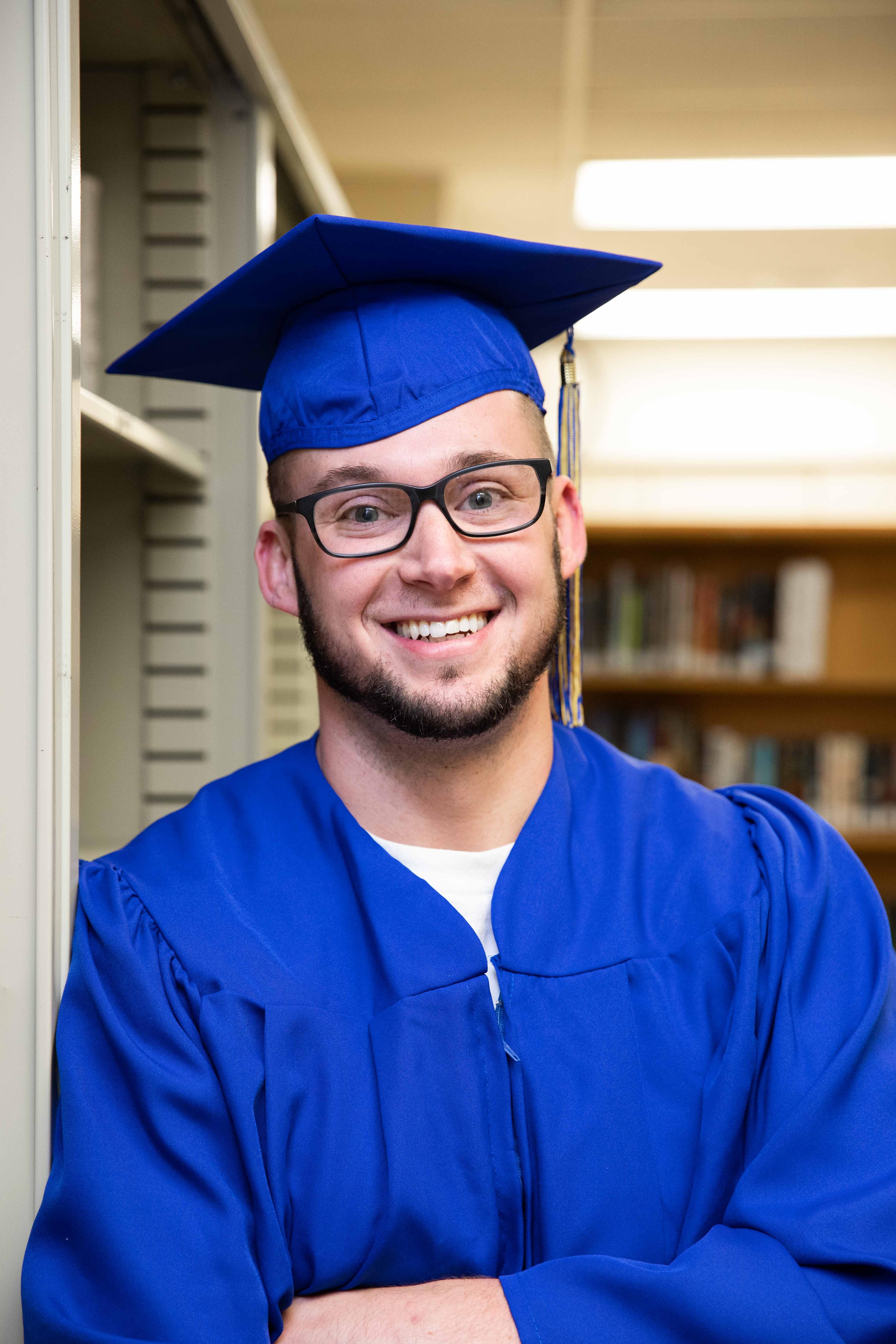 student in cap and gown in prison library