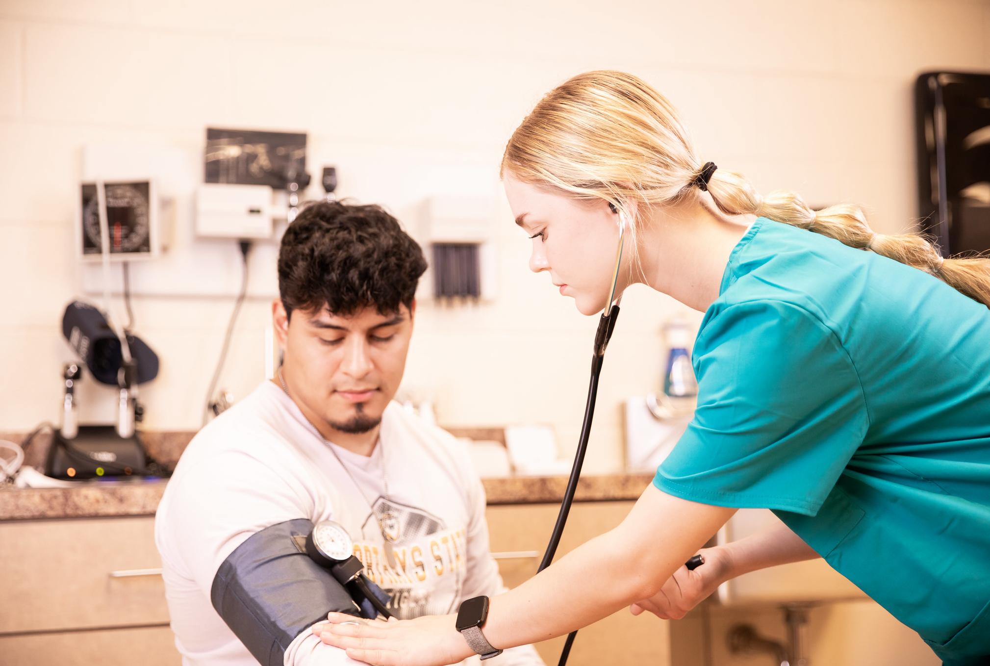 person taking another person's blood pressure