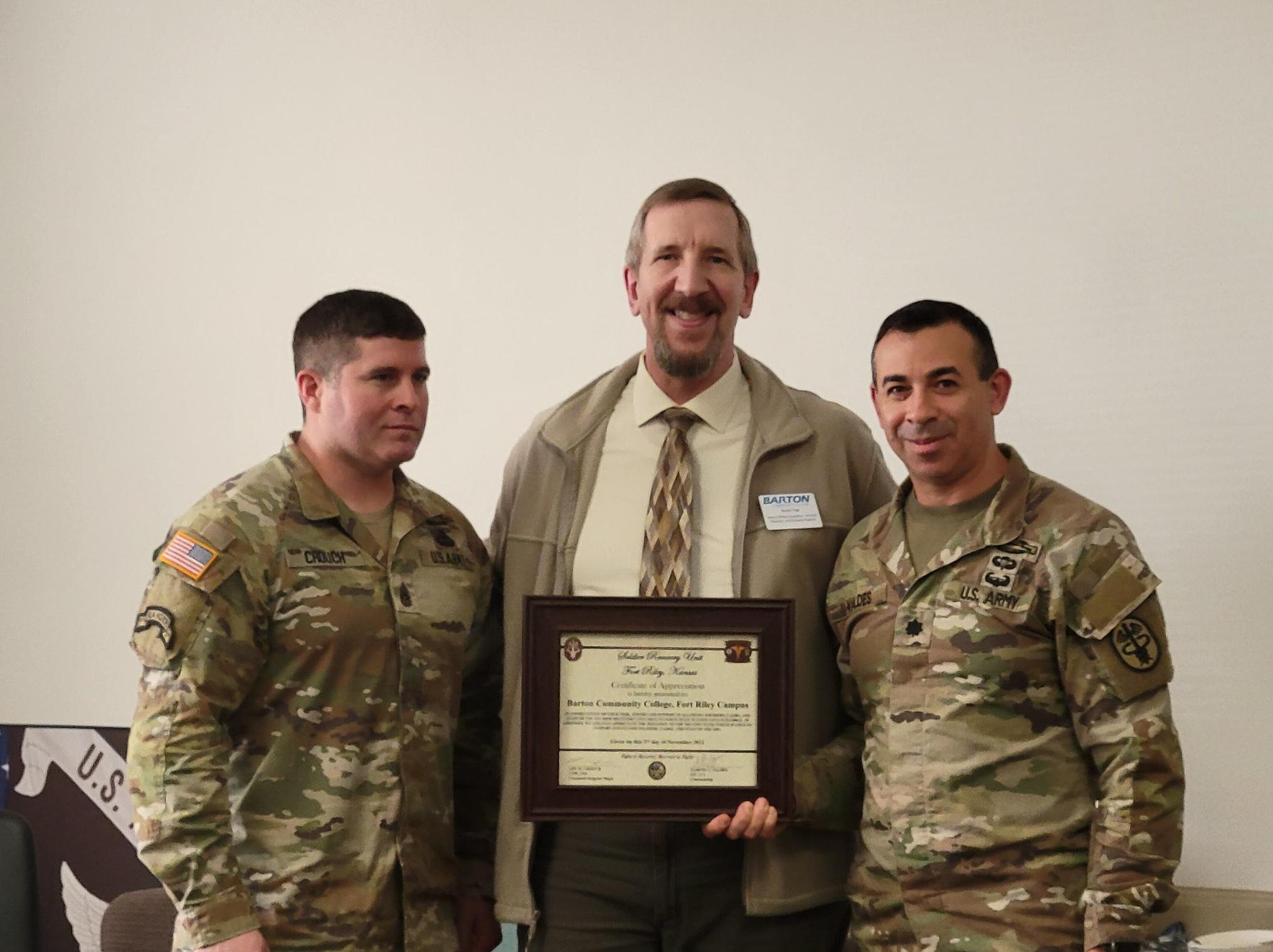 barton representative receiving a certificate of thanks from 2 soldiers