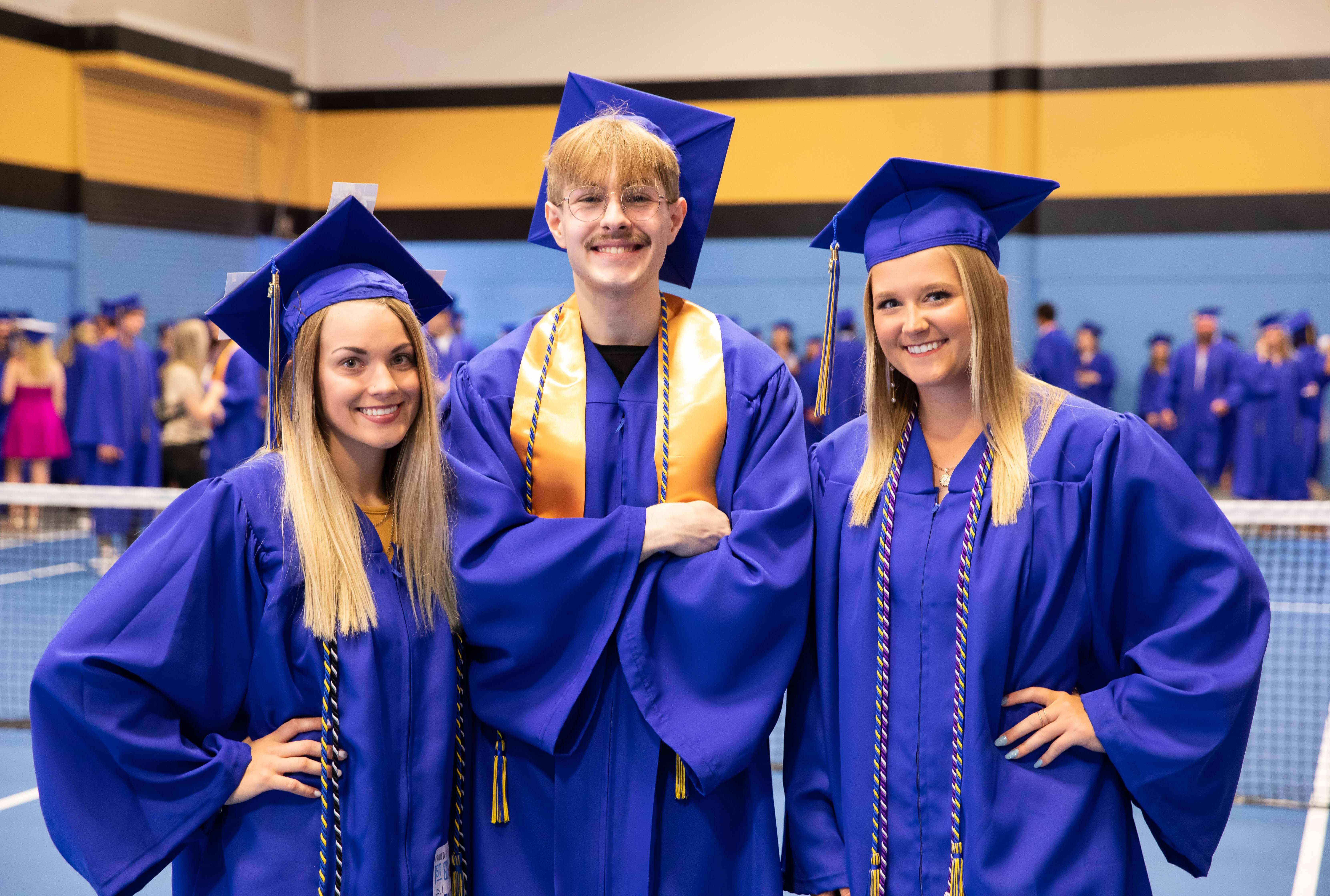 three students standing in a gym