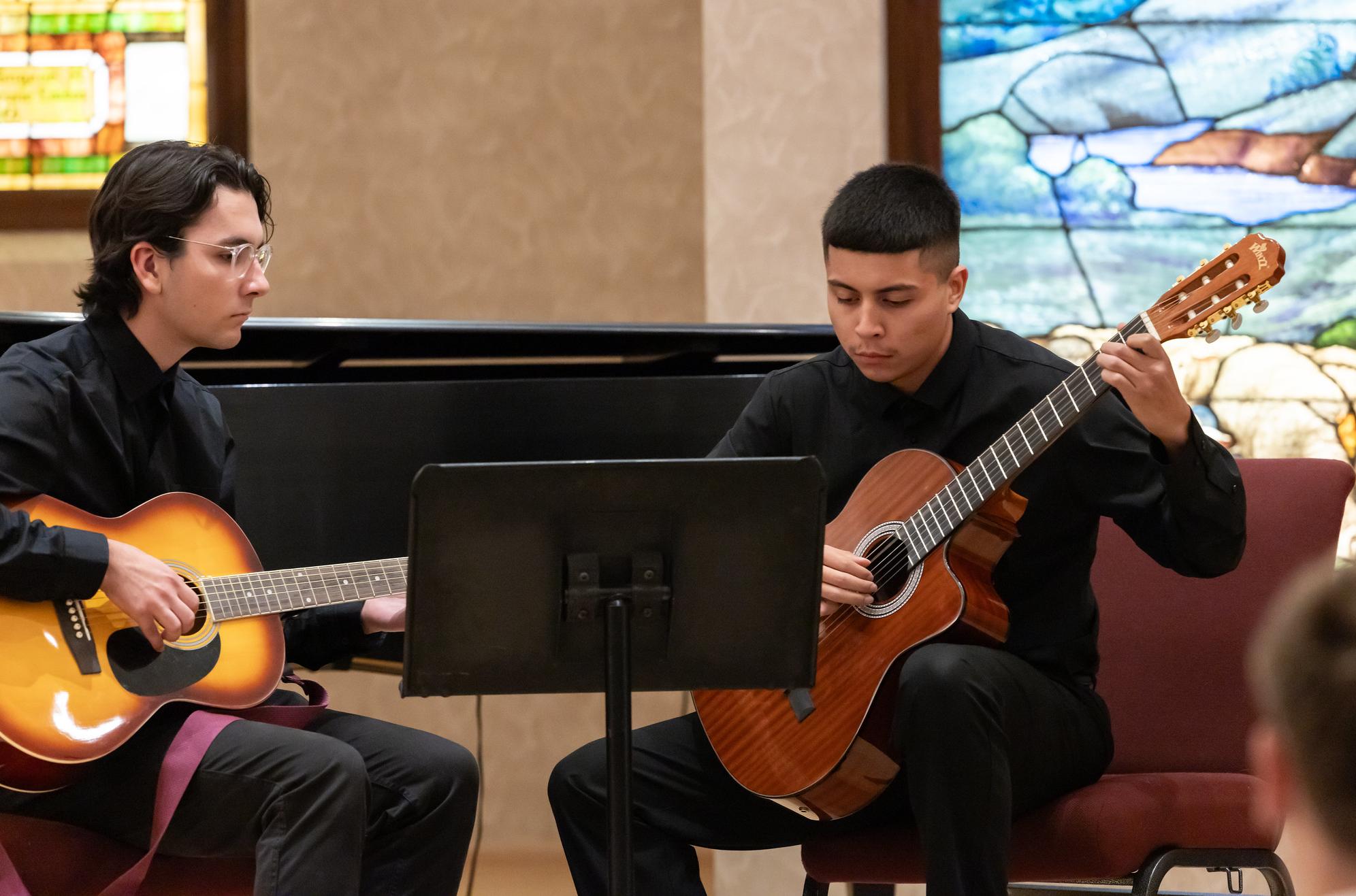 two students playing guitar