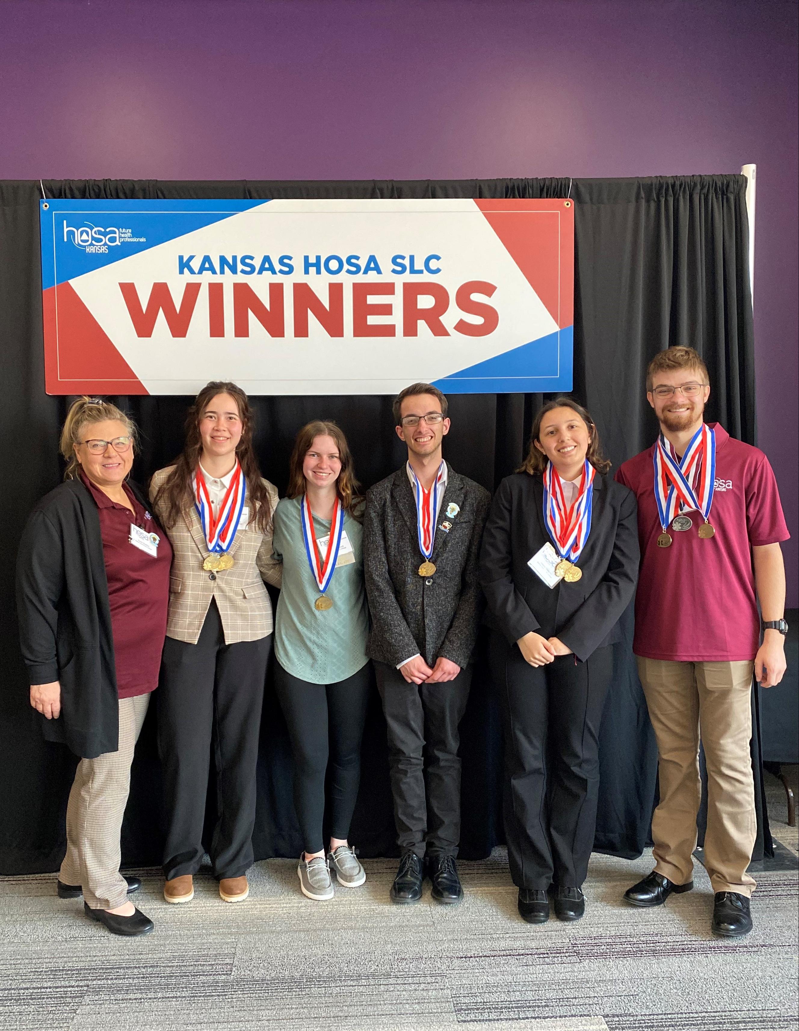 students with their advisors with their medals around their necks