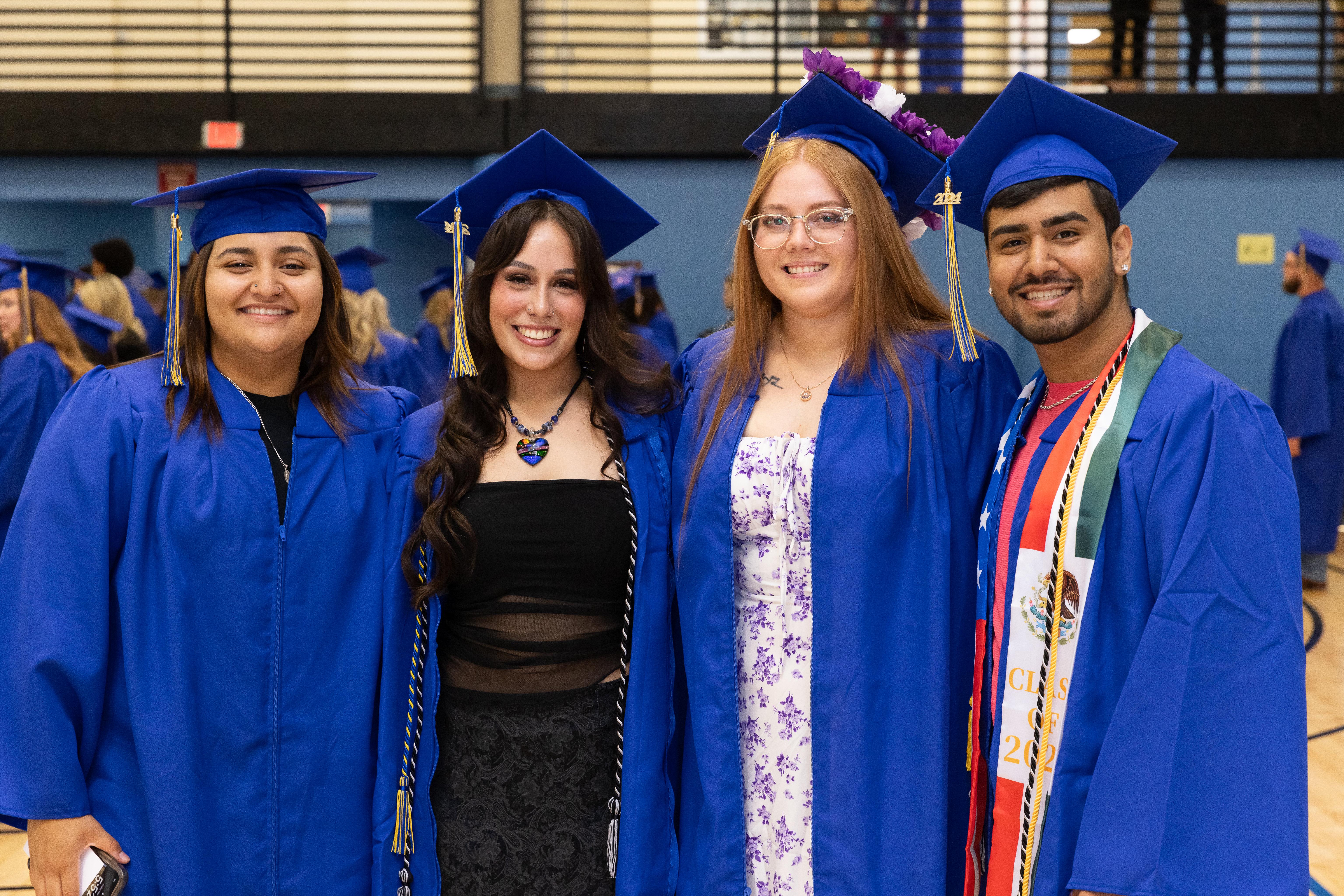 Students pause for a photo before the 2024 commencement ceremony in the Barton Gym.