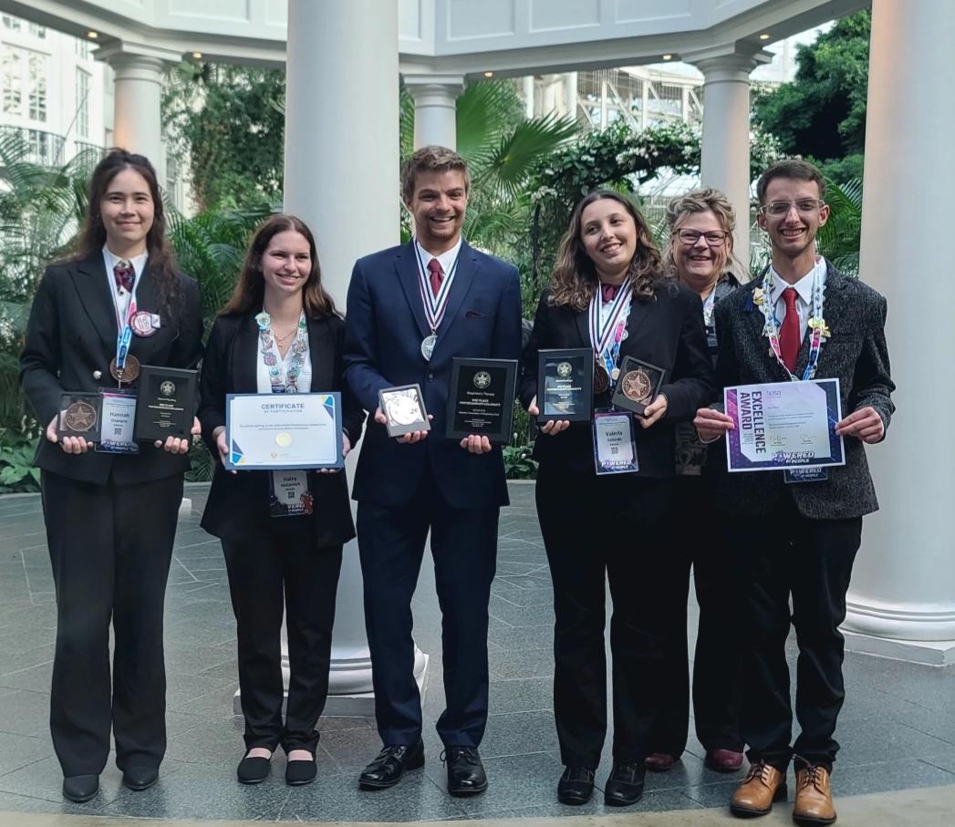 people holding awards in dress clothes