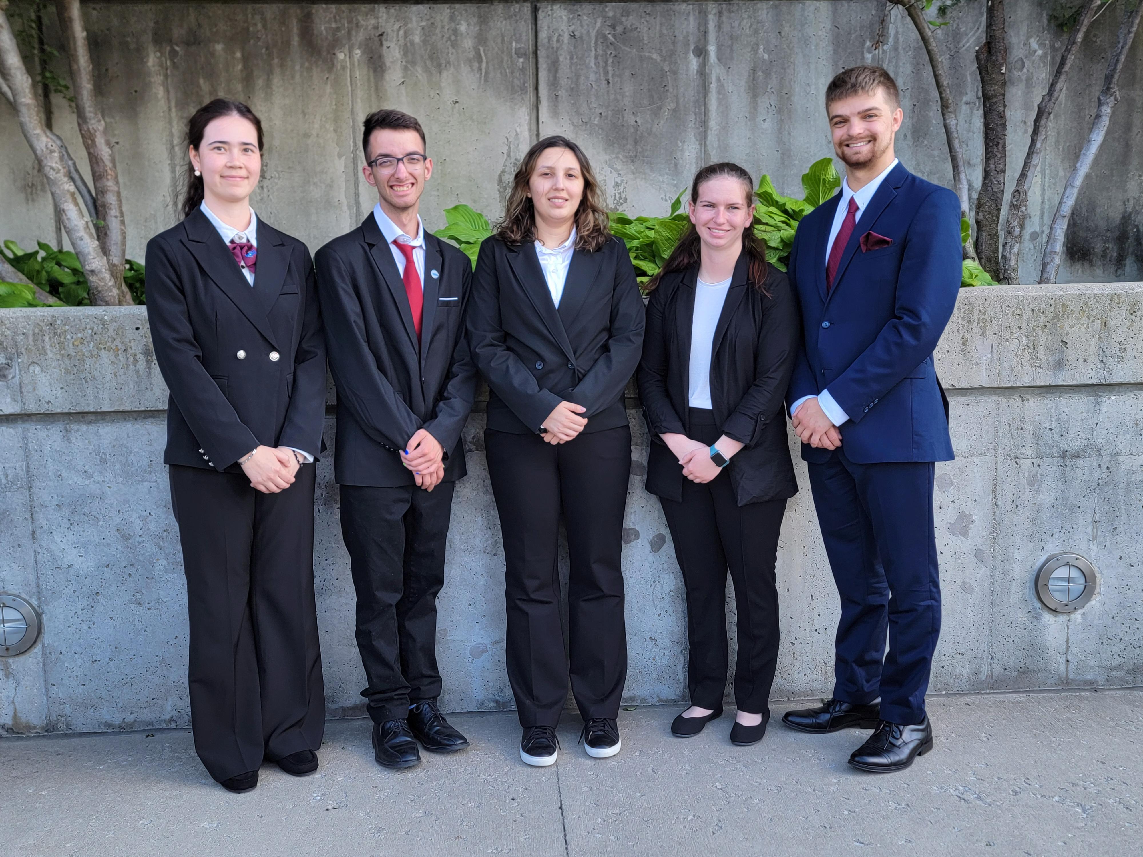 college aged students in business attire posing for photo