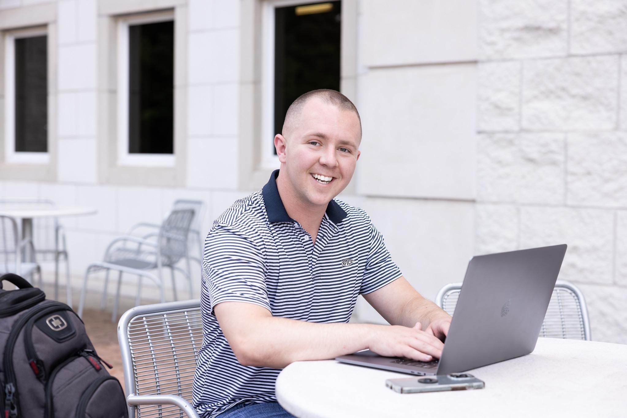 man smiling at laptop