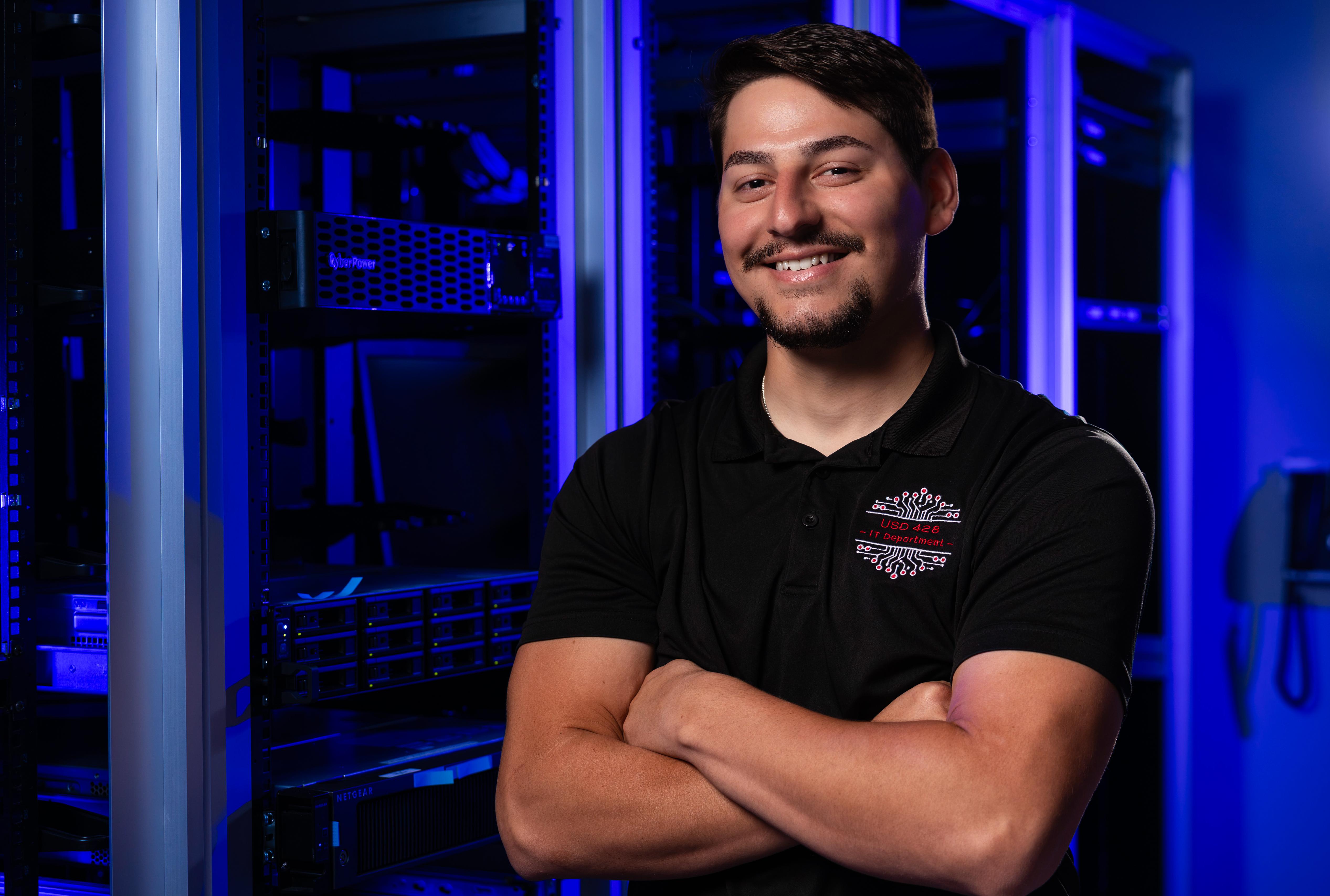smiling man in server room with blue accent lighting