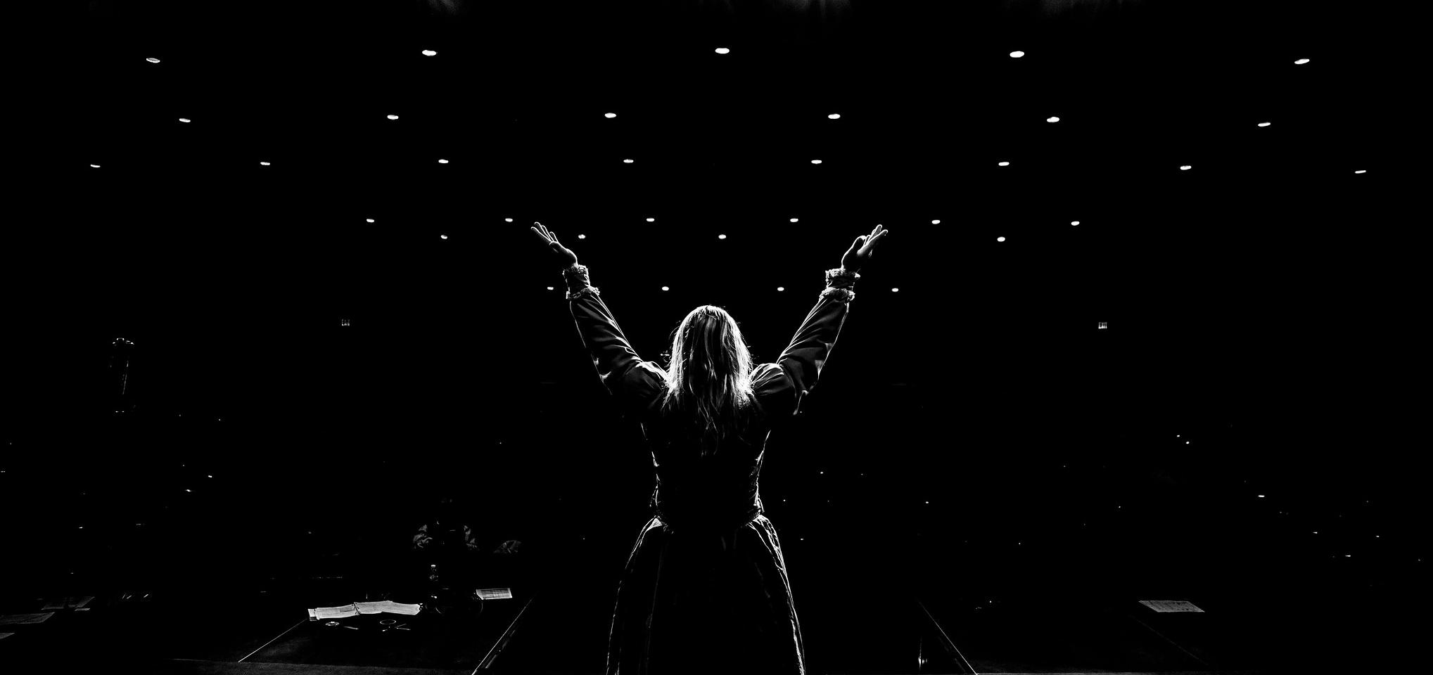 A performer stands on the stage in the Barton Auditorium