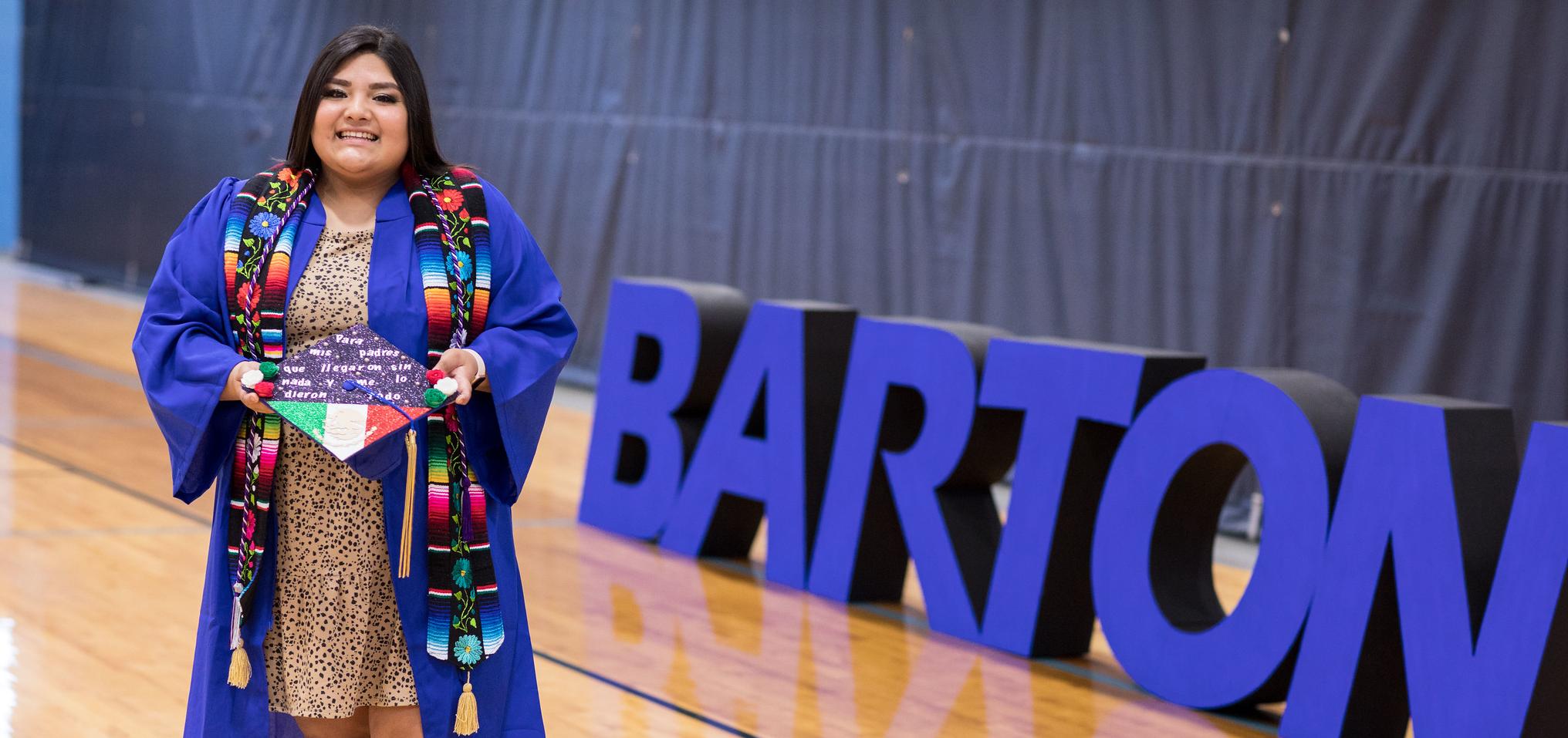 A student poses for a photo following commencement