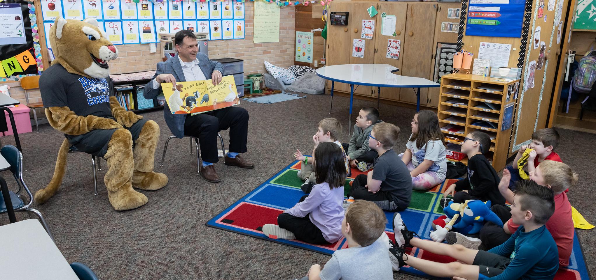 Barton president and Bart the cougar read to elementary students