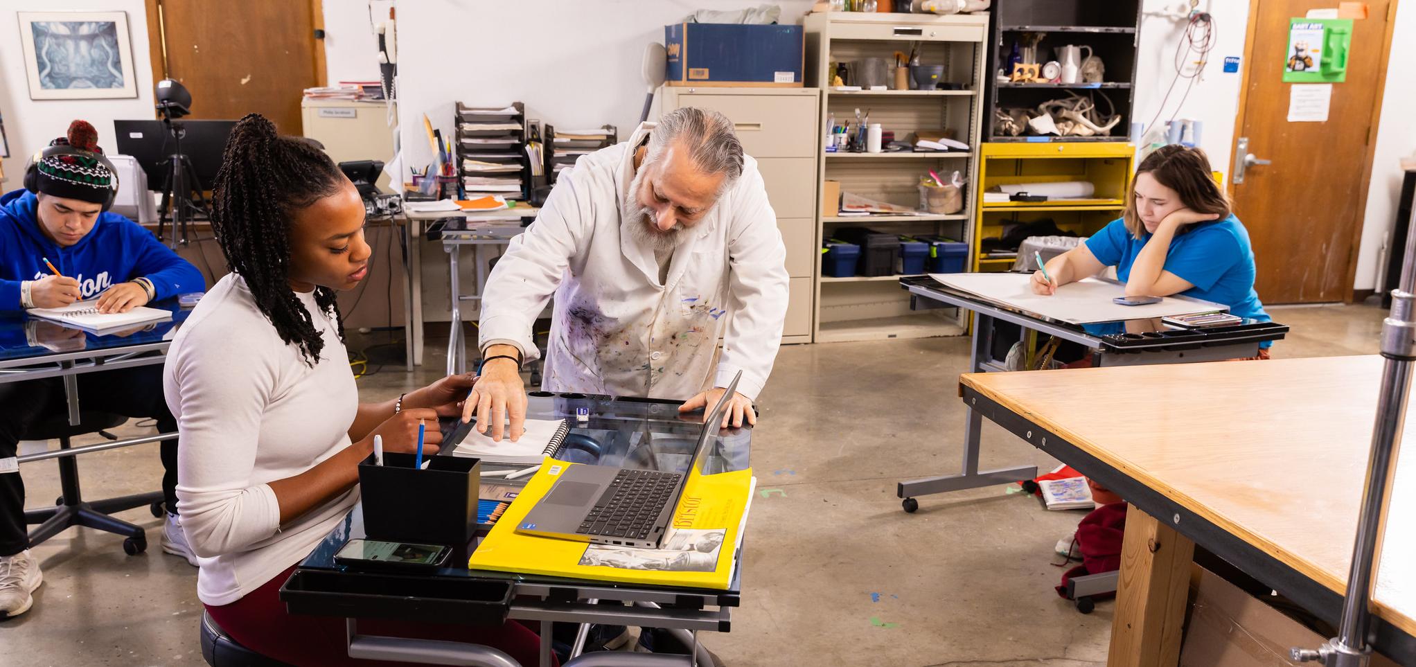 Art professor instructs students in art studio