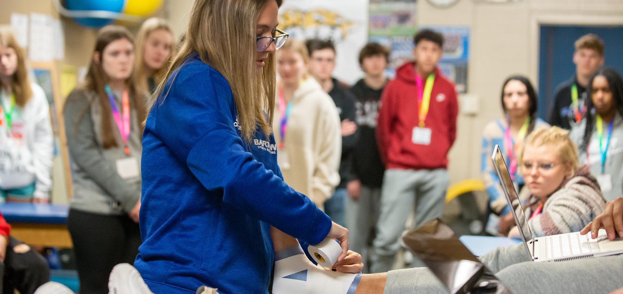 Athletic Trainer demonstrates taping 