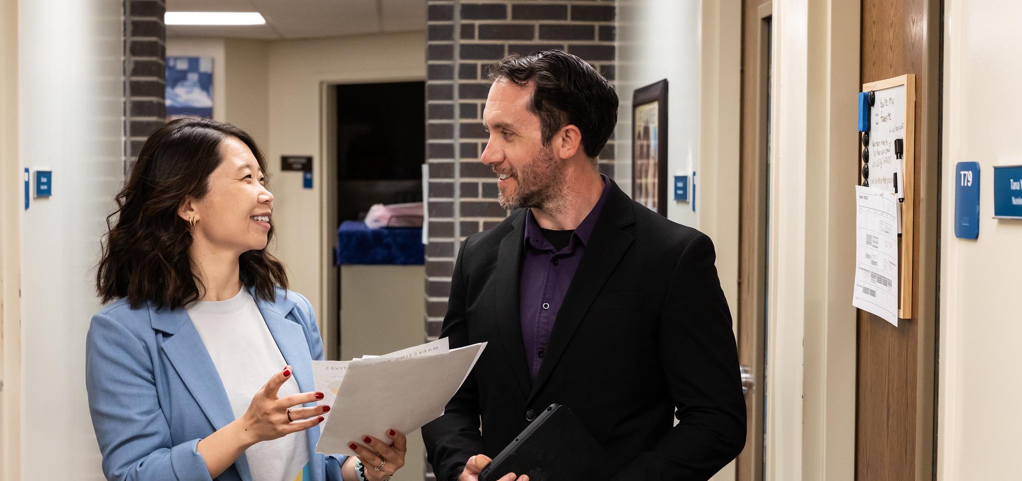 Two employees meet in the hallway for business meeting