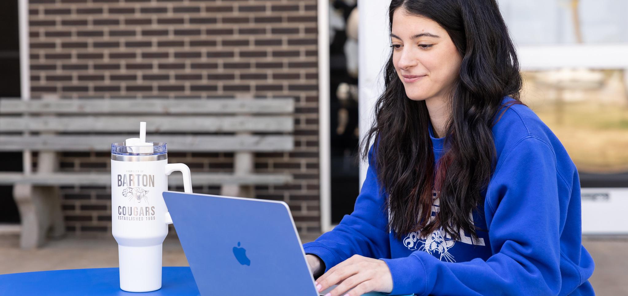 Student types on laptop on Barton Campus