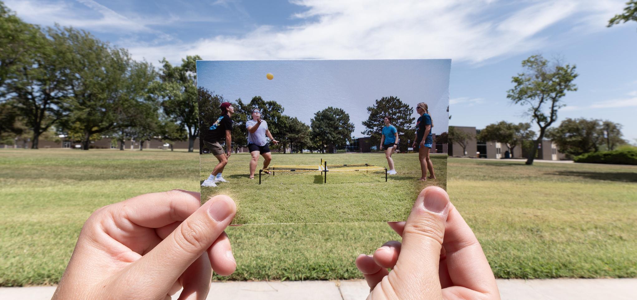 Students play in grass on campus