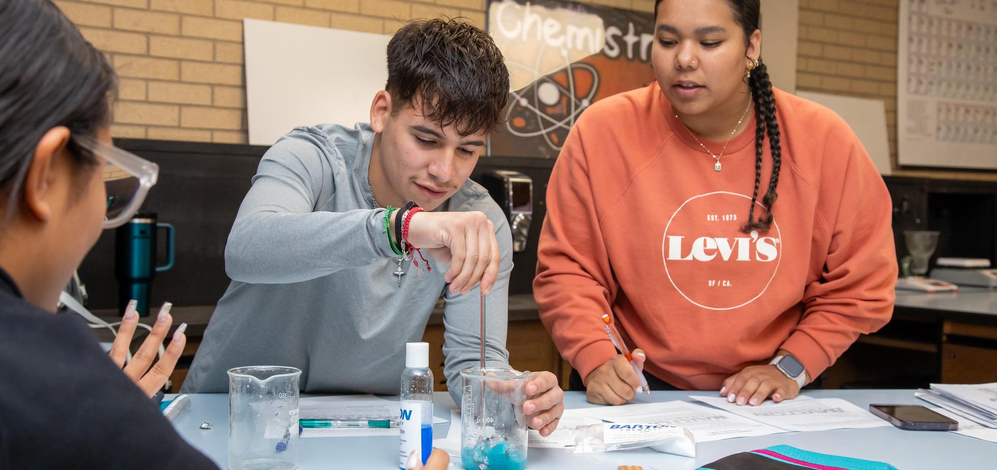 Students in a chemistry lab perform experiment with chemicals