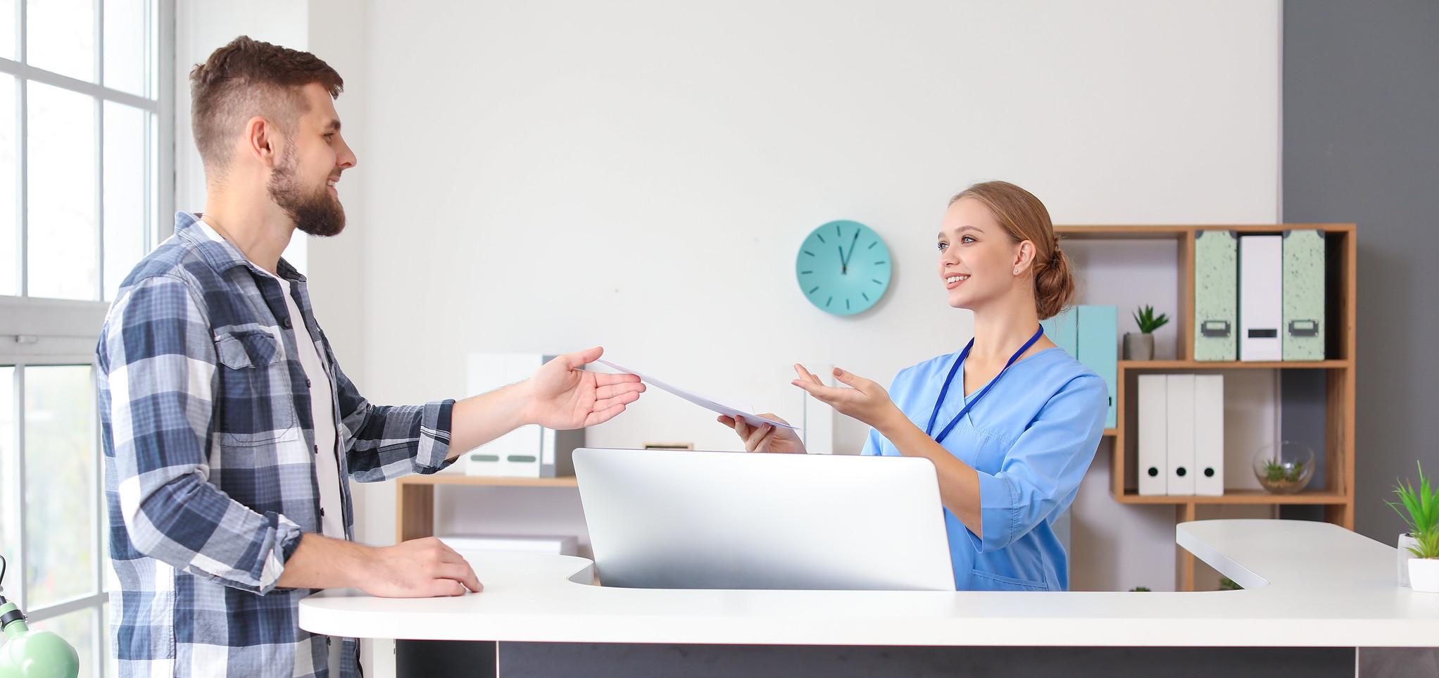 A Med Admin Tech helps a patient with files. 