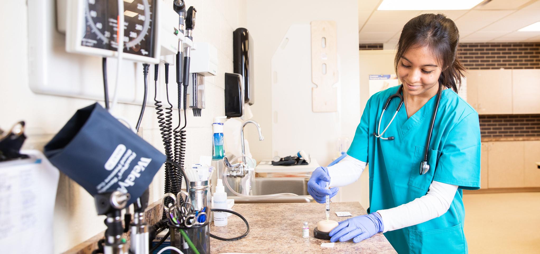 A medical assistant student practices in lab