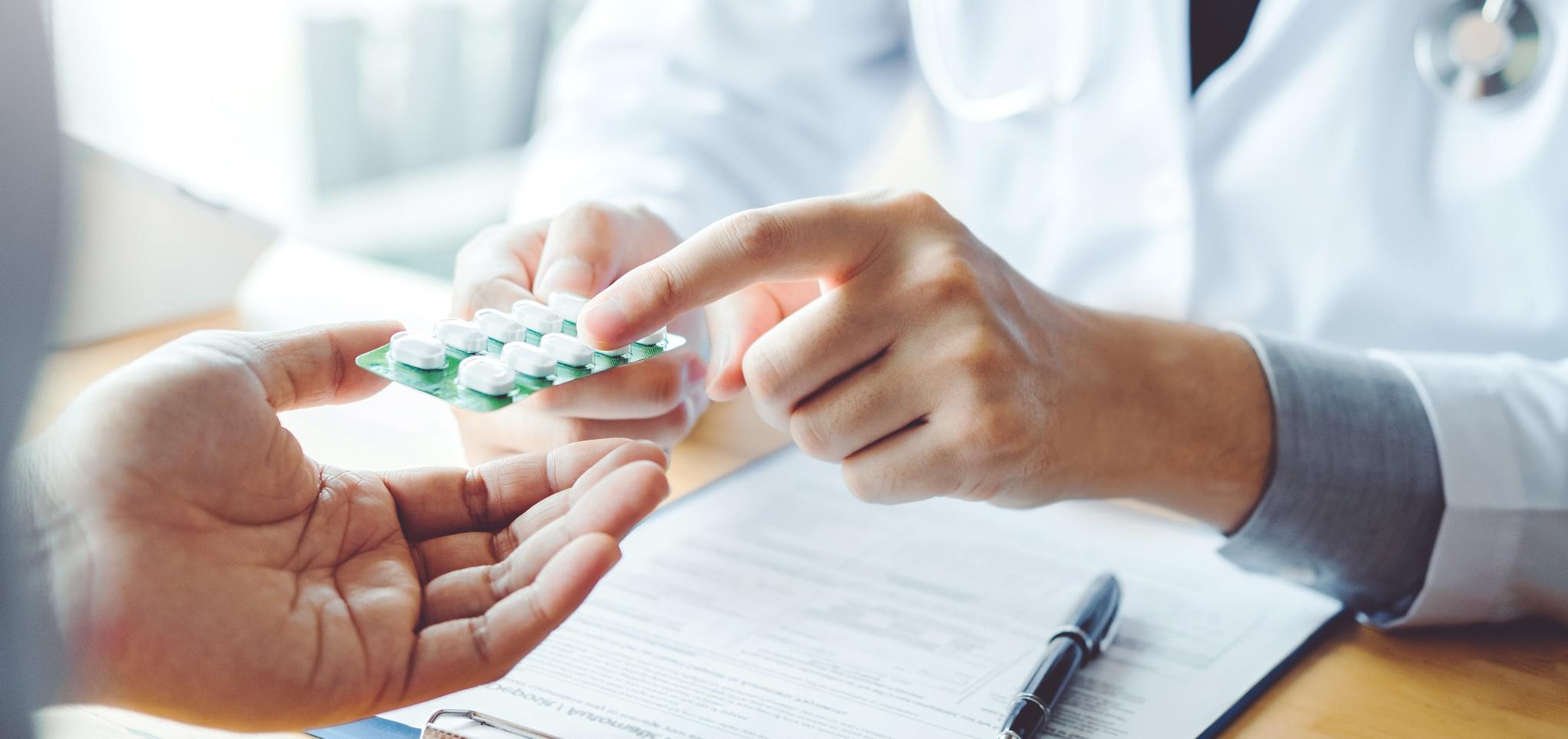 Doctor holds prescription pills in hands