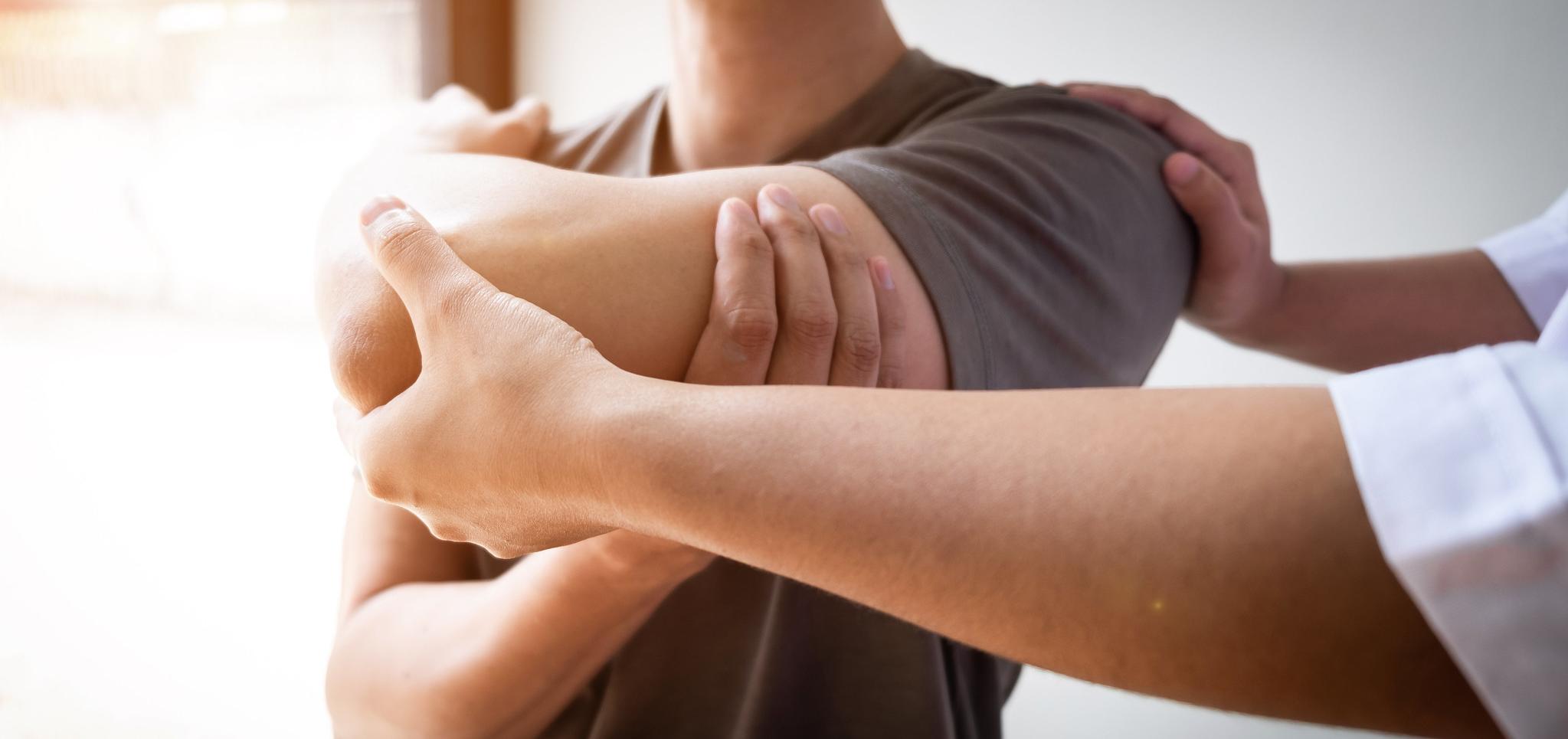 Professional helps patient through physical therapy appointment