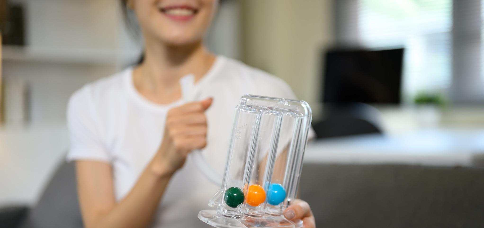 A patient uses a spirometer