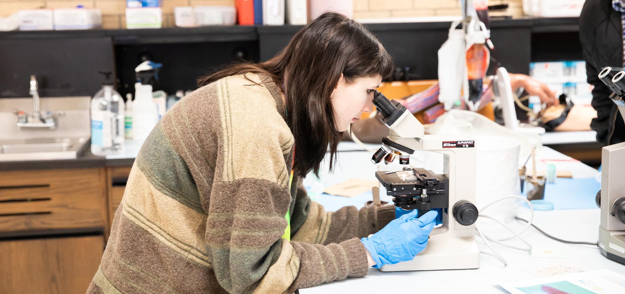 Student looks through microscope in Barton science classroom