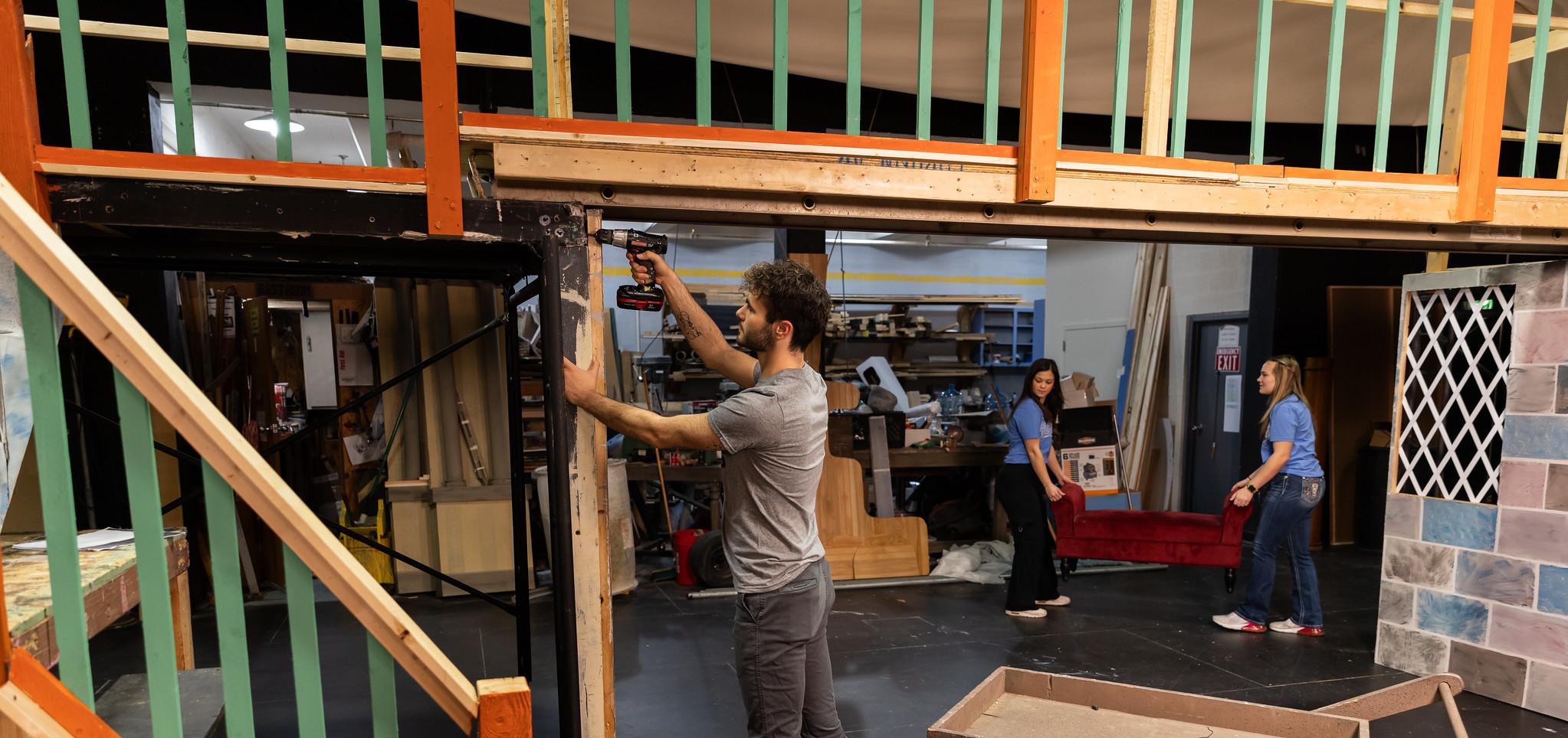 Barton technical theatre students work back stage on a set