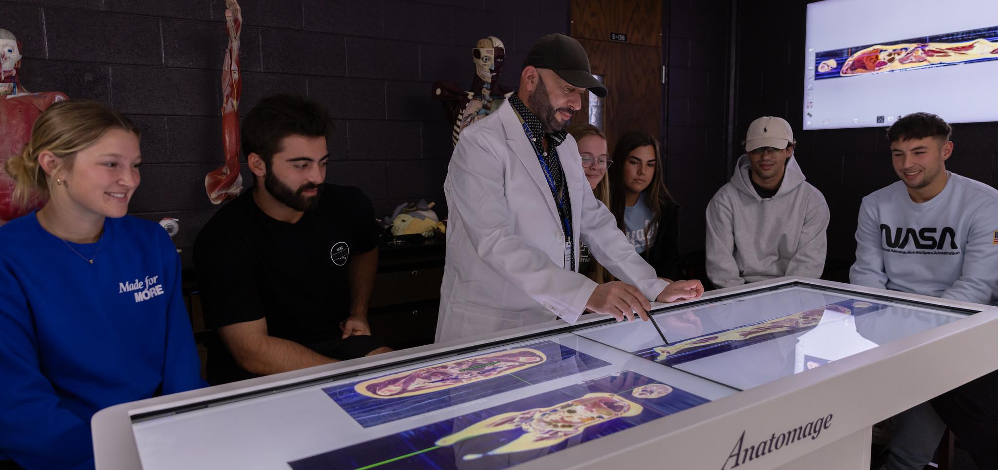 Instructor displays skeleton on anatomage table